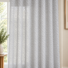 Textured semi-sheer white curtains with tab-top heading in a modern living room